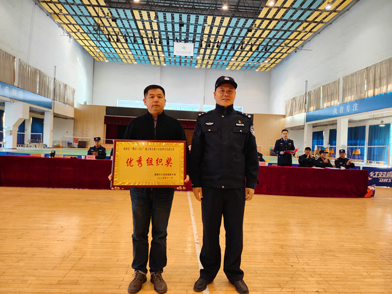 渭南市公安局高新分局党委委员、副局长薛凯为我校代表颁发优秀组织奖奖牌并合影留念