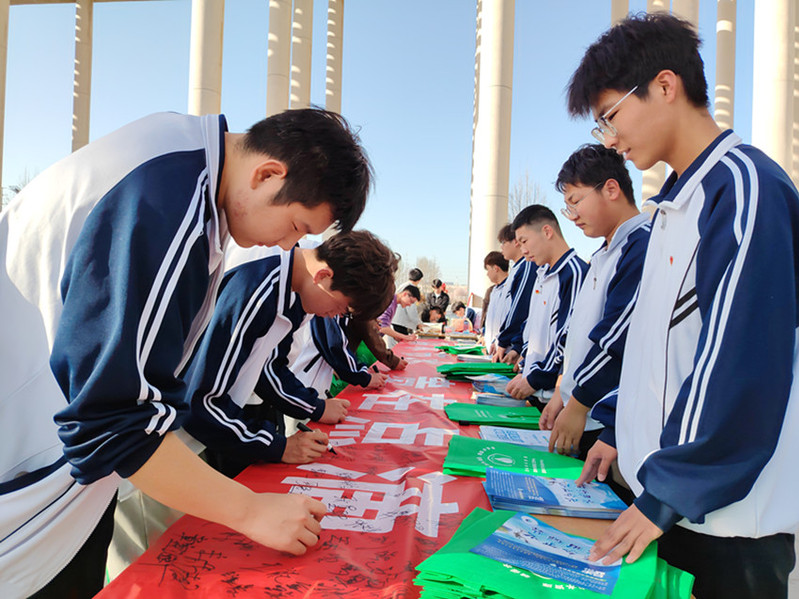 学生在主题宣传横幅上签字