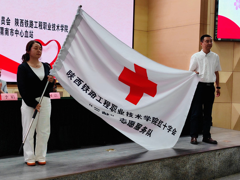 渭南市红十字会常务副会长郭维为我校红十字会“三献”志愿服务队授旗