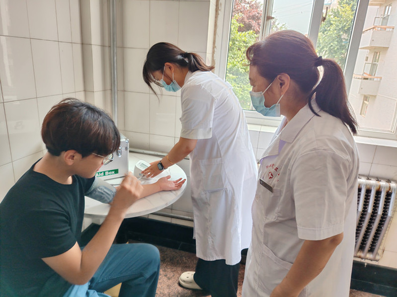 医疗小组对模拟被困师生开展身体检查，实时监测血压、问询身体状况，做好应急医疗保障。