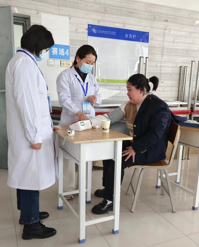 一考生因考试压力过大导致呼吸急促 校医护人员在为该生测量血压