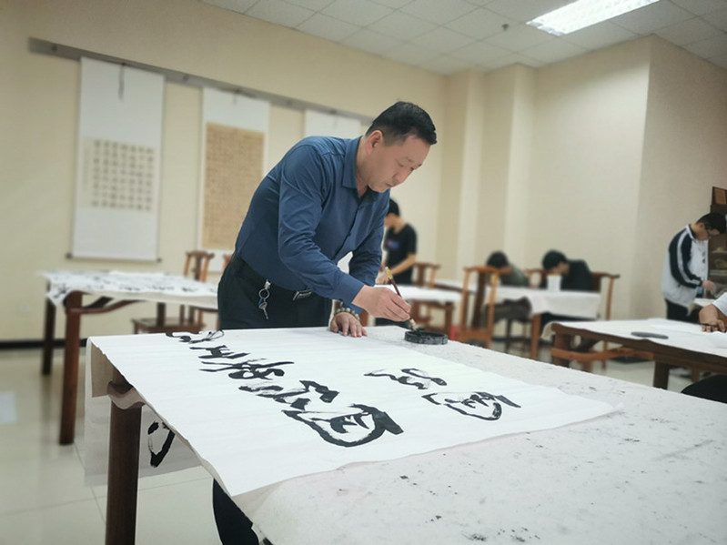 学校书法爱好者进行国家安全书法作品创作