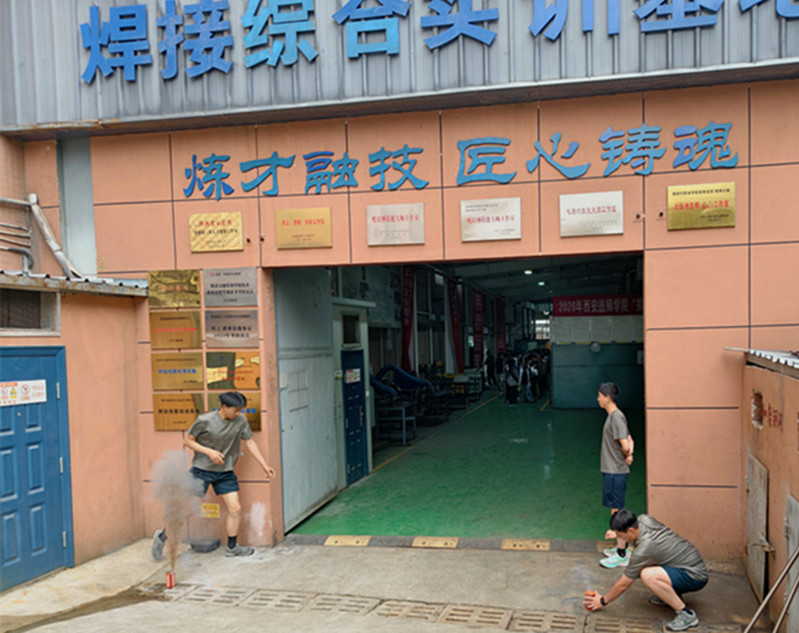 实训室外模拟烟雾弹点燃，应急疏散演练正式启动，现场烟雾弥漫，真实还原火灾现场环境