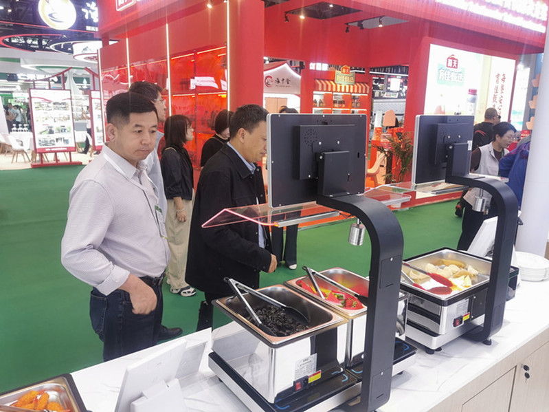 考察组了解食堂智能餐台、菜品识别结算设备
