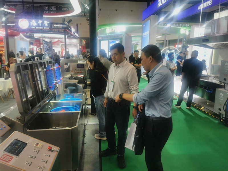 考察组在展会现场了解食堂自动化清洗设备