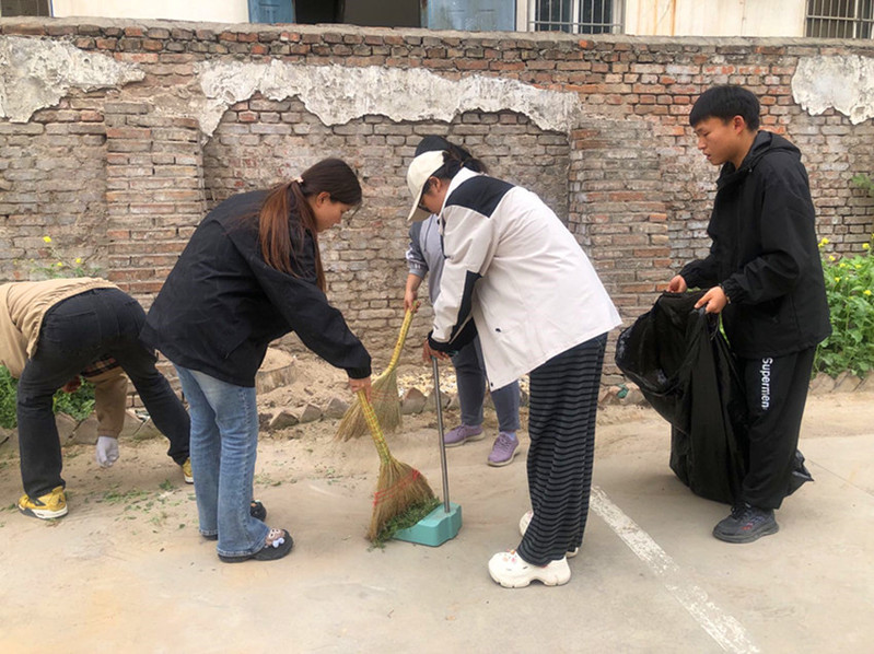 学生志愿者们打扫社区街道卫生