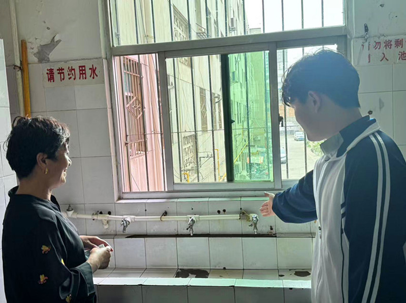 学生志愿者向社区居民宣传节水知识和节水小妙招