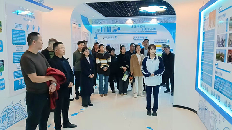观摩团成员驻足聆听节水教育基地学生讲解员宣讲