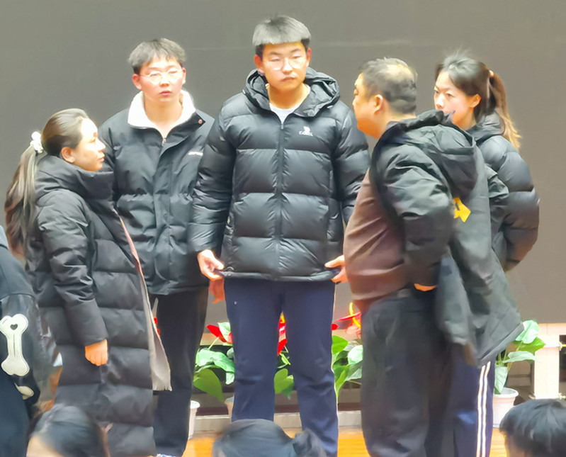 秦艳老师（左一）在赛前为参赛学生加油鼓劲