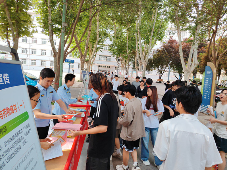 宣传现场人头攒动，多名市场监管工作人员同步为驻足咨询的学生分发宣传资料，普及药品安全与禁毒知识。